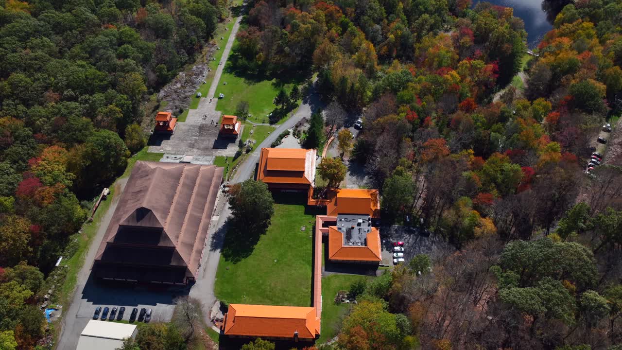 An aerial view of the Chuang Yen Monastery on a sunny fall day, the leaves of the trees begin to change for autumn