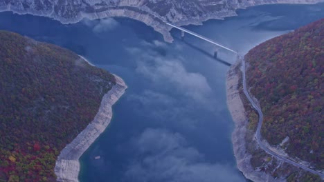 the famous lake piva with mountains of canyon in montenegro during sunrise, aerial