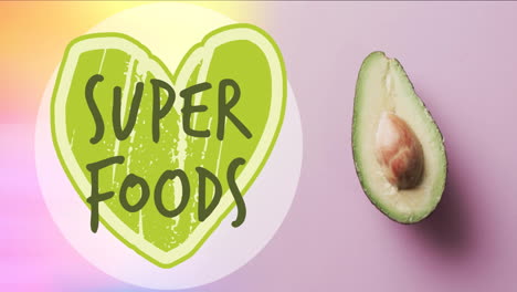 animación de superalimentos texto en corazón verde sobre aguacate dividido en dos sobre fondo rosa