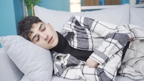 depressed young man lying down with a sigh.