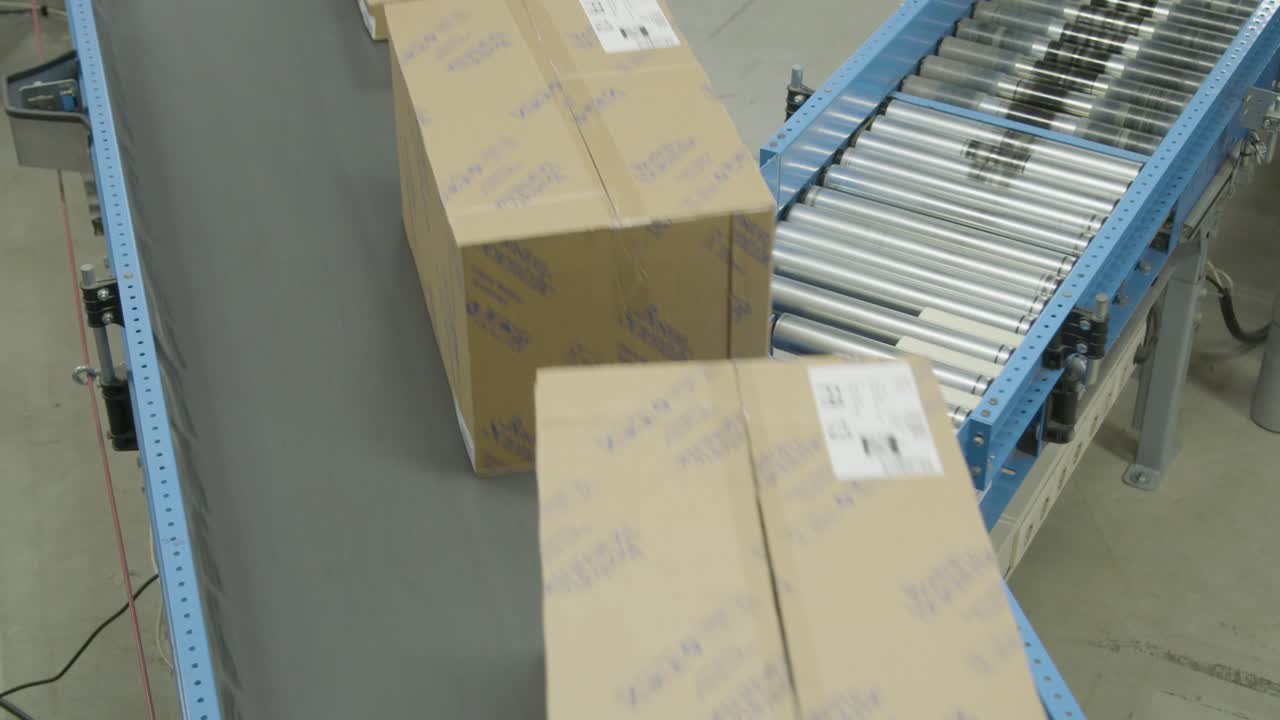 Boxes travel along a conveyor belt system inside a warehouse during sorting and processing operations