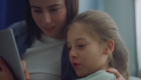 Girl-mother-holding-tablet-computer-play-online-games-together-in-room-closeup.