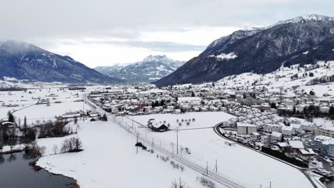 aproximación aérea 9ng de la aldea suiza llamada reichenburg y la cordillera durante un día de invierno nevado en suiza