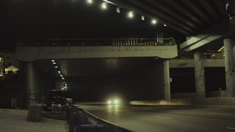 City-bridge-night-cars-passsing-underground-tunnel-in-urban-background.