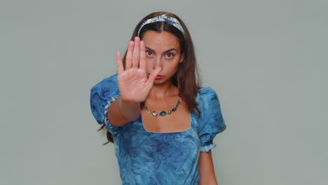 Girl-say-No-hold-palm-folded-crossed-hands-in-stop-gesture,-warning-of-finish,-prohibited-access