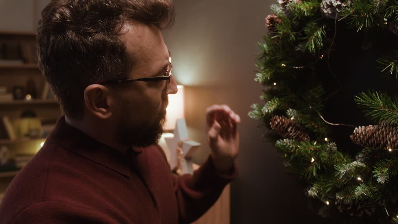 Man hanging a Christmas wreath