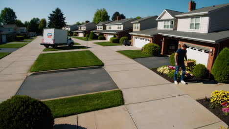 man delivers or handles a package at a suburban home's front door
