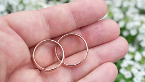 wedding rings offered by hand outdoors