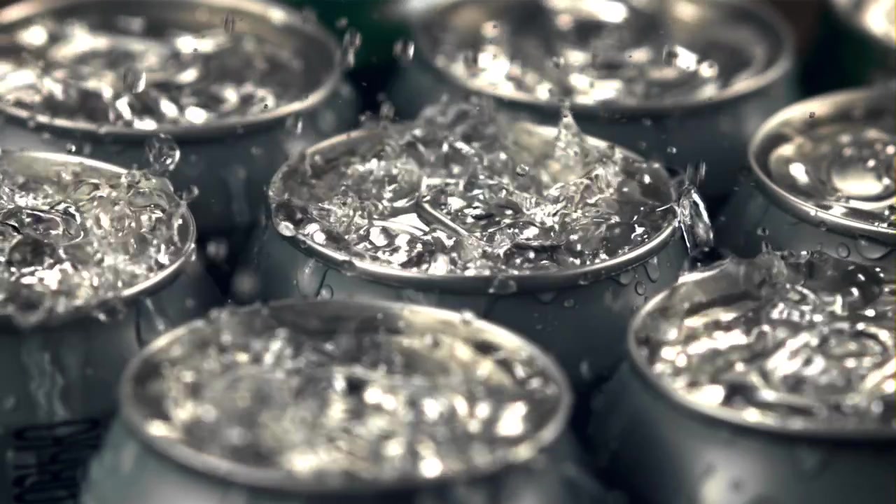 Acqua rinfrescante che schizza su lattine di bevande fredde in alluminio al rallentatore