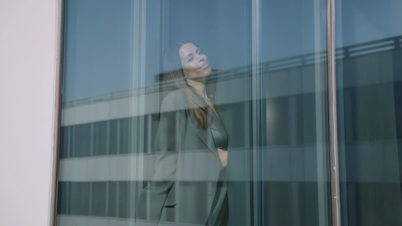 Businesswoman Looking Out of a Modern Office Window
