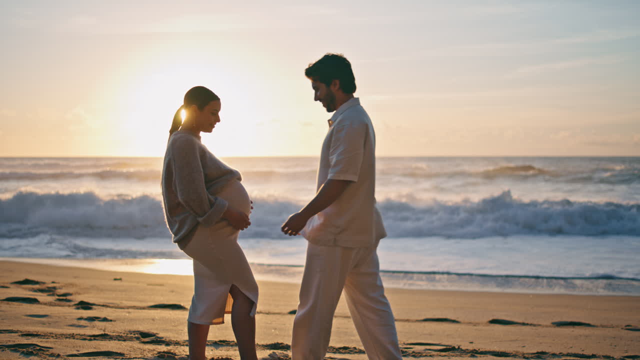 임신 한 커플 이 해 가 지는 동안 포옹 하고 행복 을 느다. 해가 지는 동안 임신 한 부모
