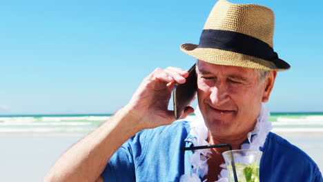 älterer mann spricht am handy am telefon am strand