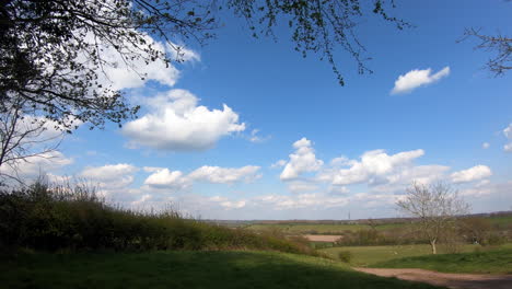 A-bright-Spring-day-in-the-Worcestershire-countryside,-UK-as-white-fluffy-clouds-speed-by-in-a-time-lapse