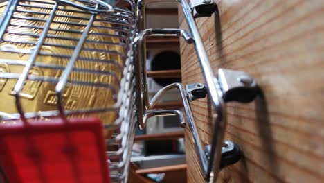 vertical clip: gold bitcoin crypto currency in tiny shopping cart on kitchen table concept low angle reversing shot