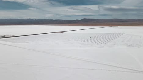 toma aérea de drones de las salinas blancas argentinas que se cierran en los colores azul claro cristalino de las piscinas de agua