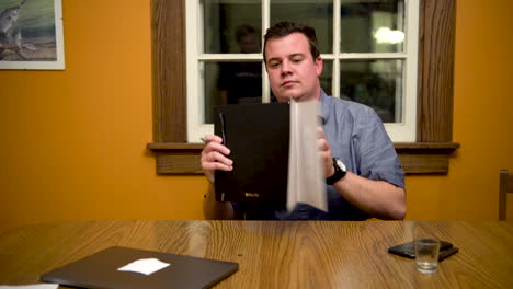 el hombre en la mesa escribe en el cuaderno, luego pasa las páginas