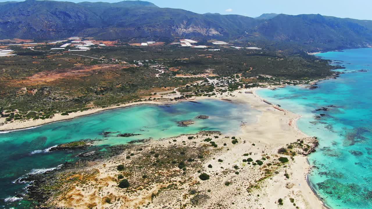 Aerial: Bird's eye view of famous Elafonissi beach and azure crystal clear blue water during a hot sunny day