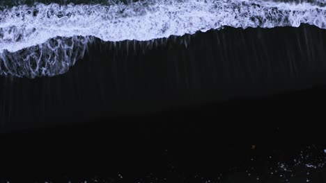 black sand beach with foamy white waves of atlantic ocean