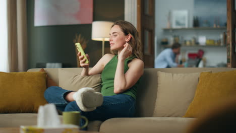 mujer positiva leyendo teléfono móvil casa. feliz mujer relajada navegando por teléfono celular