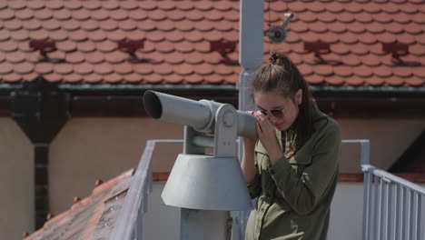 mujer mirando a través de un telescopio en un techo