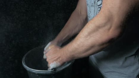 athlete applying chalk to hands for weightlifting