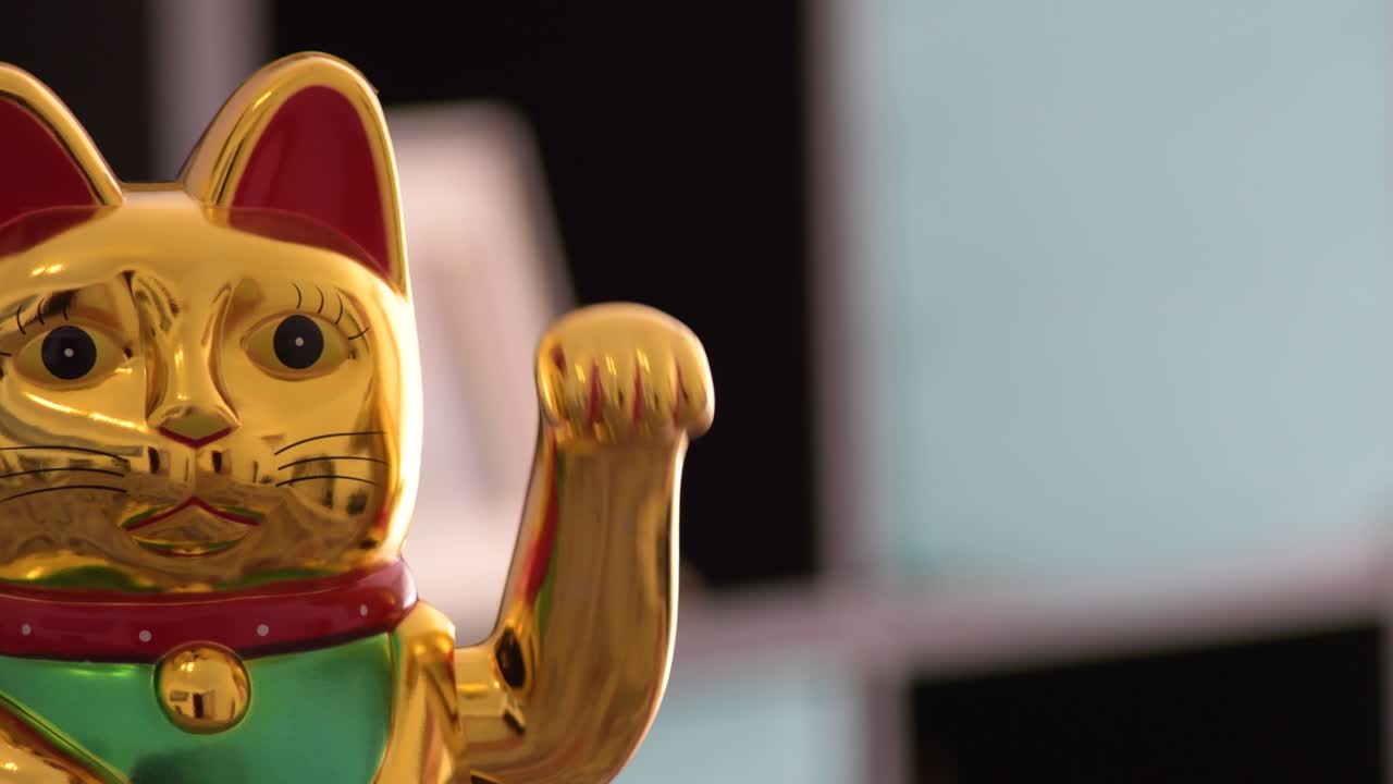 el gato de la suerte chino, maneki neko, moviendo el brazo.