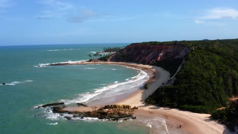 Increíblemente-Hermoso-Drone-Aéreo-Bajando-La-Toma-De-La-Playa-Tropical-De-Tabatinga-Con-Grandes-Acantilados-Coloridos,-Agua-Verde-Y-Hermosa-Arena-Cerca-De-Joao-Pessoa,-Brasil-En-Un-Cálido-Día-Soleado-De-Verano