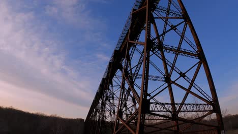 walking under a beautiful, high, steel, beautifully engineered train bridge viaduct in the appalachian mountains during early spring