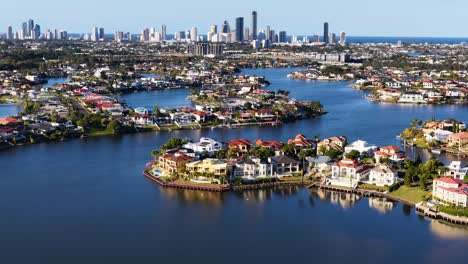 high-resolution drone footage glides over luxury waterfront estates, river inlets, and urban skyline under bright daylight in gold coast, australia