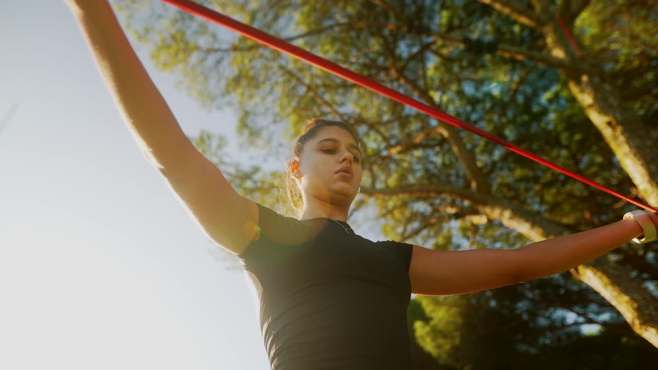 mujer haciendo ejercicio con banda de resistencia al aire libre