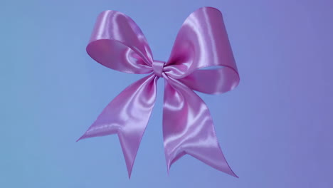 shiny pink satin bow on a gradient background