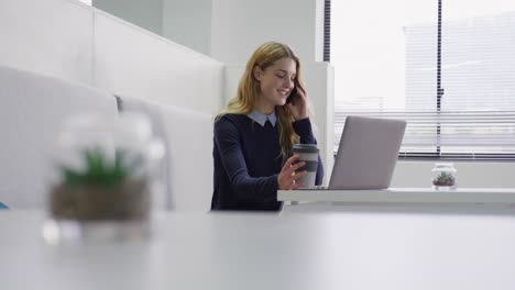 Caucasian-woman-drinking-coffee-while-working