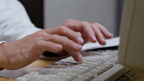 un hombre irreconocible escribiendo en el teclado.