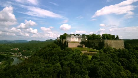 Bellas-Imágenes-Aéreas-De-Drones-Descendiendo-Y-Retrocediendo-Desde-Un-Castillo-Emblemático-En-La-Colina-En-El-Medio-De-Europa-En-Un-Día-Parcialmente-Nublado