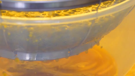 juice drips through into a bowl from passion fruit pulp