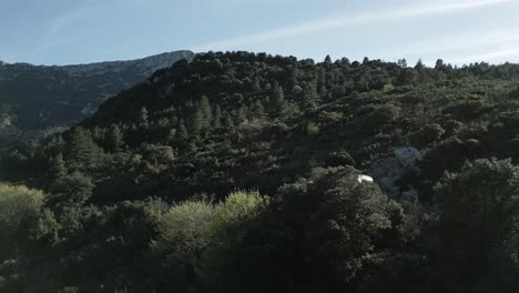 Aerial-Drone-Shot,-Camping-Can-Caravan-Van-Drives-the-Mountain-Hills-South-of-France,-Green-Landscape-in-Warm-Summer