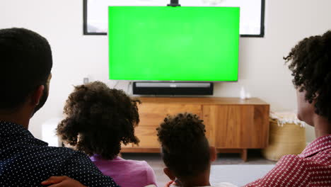 Vista-Trasera-De-Una-Familia-Con-Niños-Sentados-En-El-Sofá-Viendo-La-Televisión-Juntos.