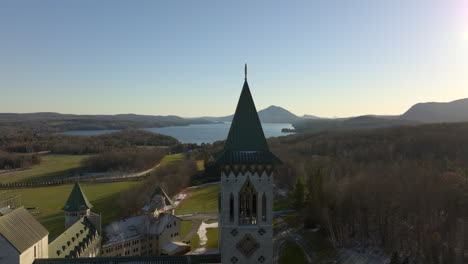 saint benedict abbey overlooking lake memphremagog in quebec, canada - aerial ascending