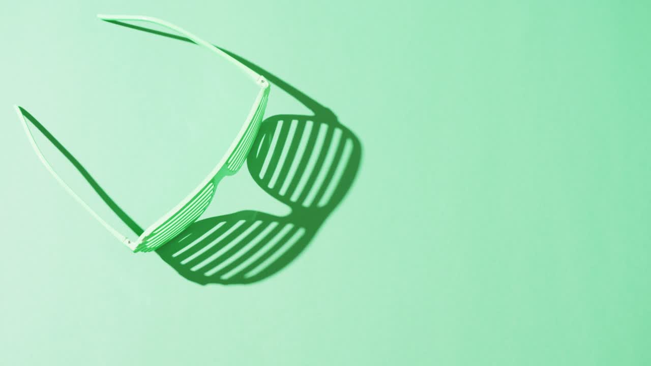 Video of st patrick's green glasses with copy space on green background