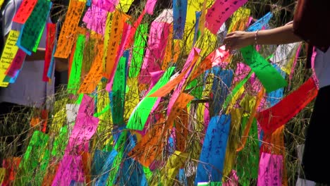 gente uniendo deseos en papel a un árbol en el templo zozo-ji