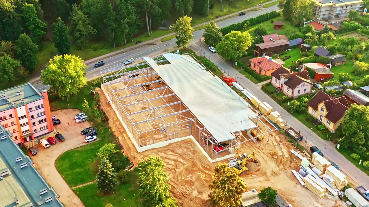 New construction of retail store or warehouse with built steel frame in aerial view in summer evening