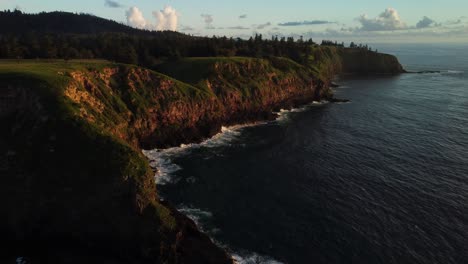 Beautiful-and-tranquil-aerial,-cinematic-ocean-coastline-at-sunset-scenery