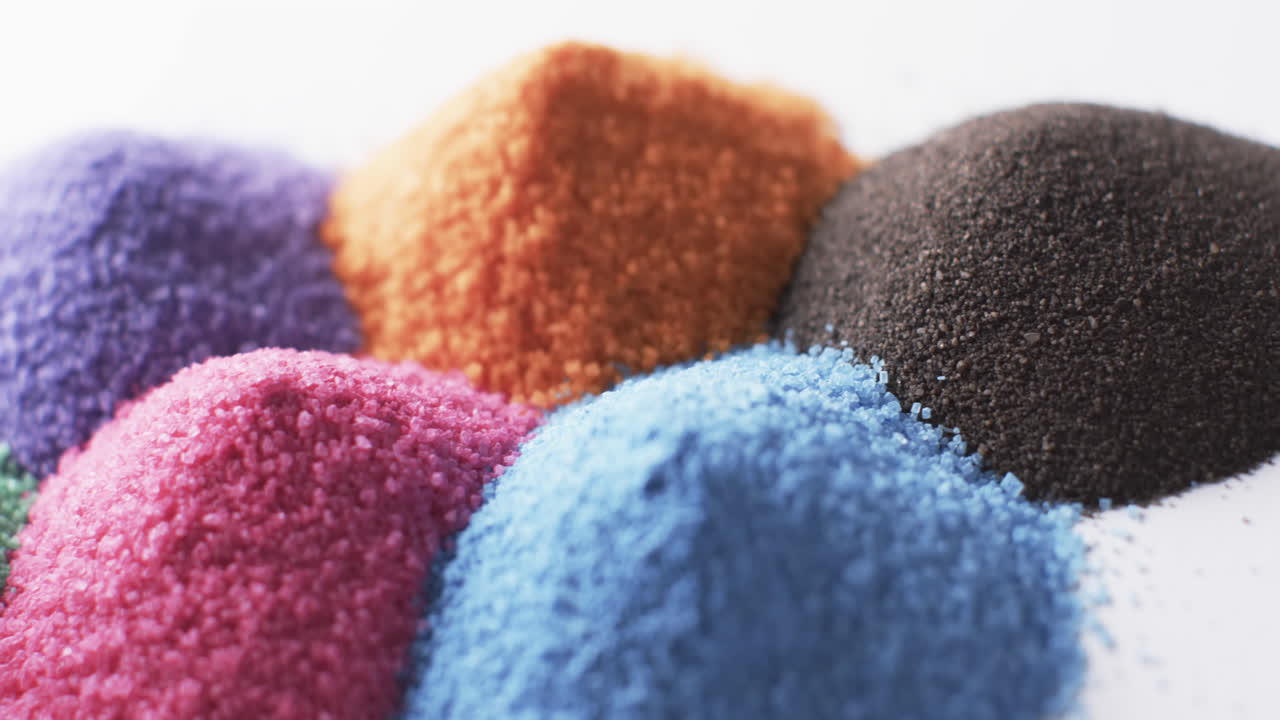 다채로운 모래 알 ⁇ 이  ⁇ 어리의 클로즈업 비디오와  ⁇ 색 배경의 복사 공간