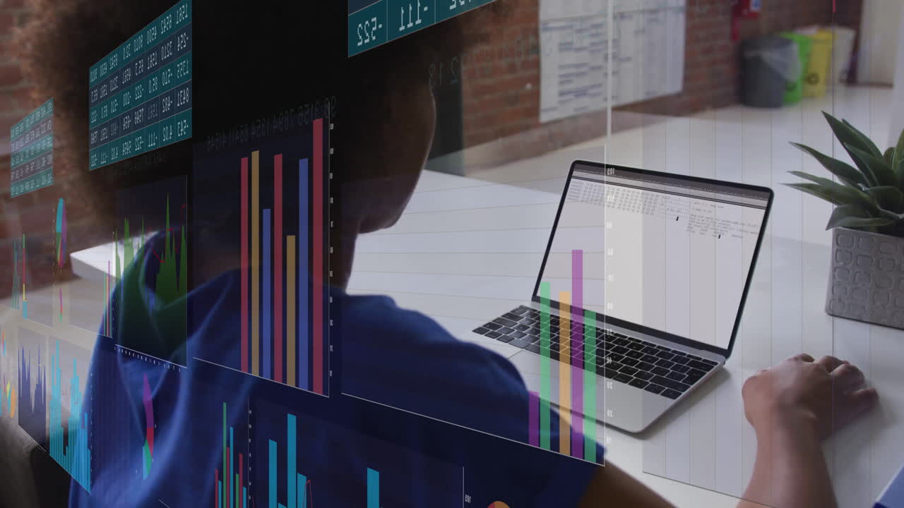 Working on laptop at desk, person analyzing colorful bar graphs and animation charts