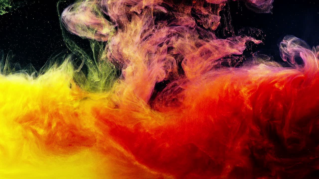 Inchiostro giallo e rosso vibrante che si mescola in acqua su sfondo nero