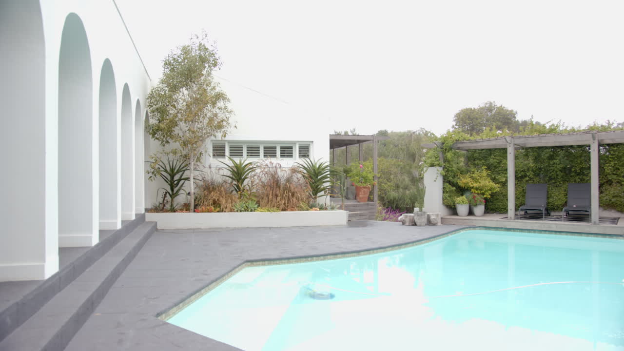 Giardino moderno con piscina e vegetazione lussureggiante, perfetto per il relax, con spazio per il testo.