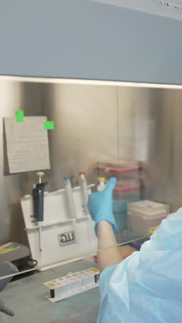 samples in biological laboratory. close up of scientist takes out one small test tube. vertical video