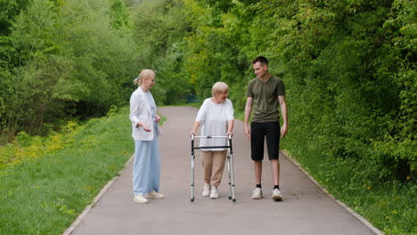 elderly woman receiving assistance while walking in a park