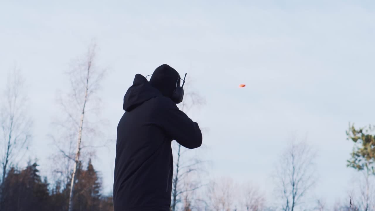 Adult Male Hunter Clay Pigeon Shooting With Shotgun Outside. Follow Shot