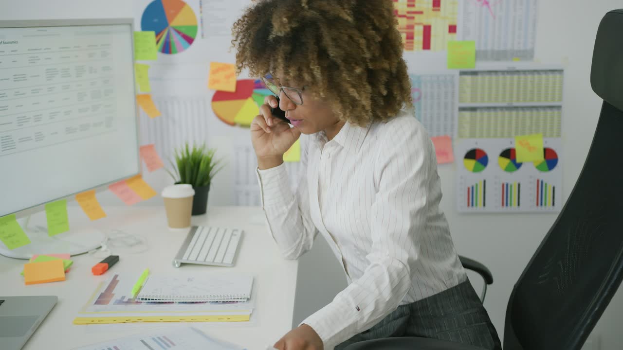 Thoughtful woman in office talking on phone